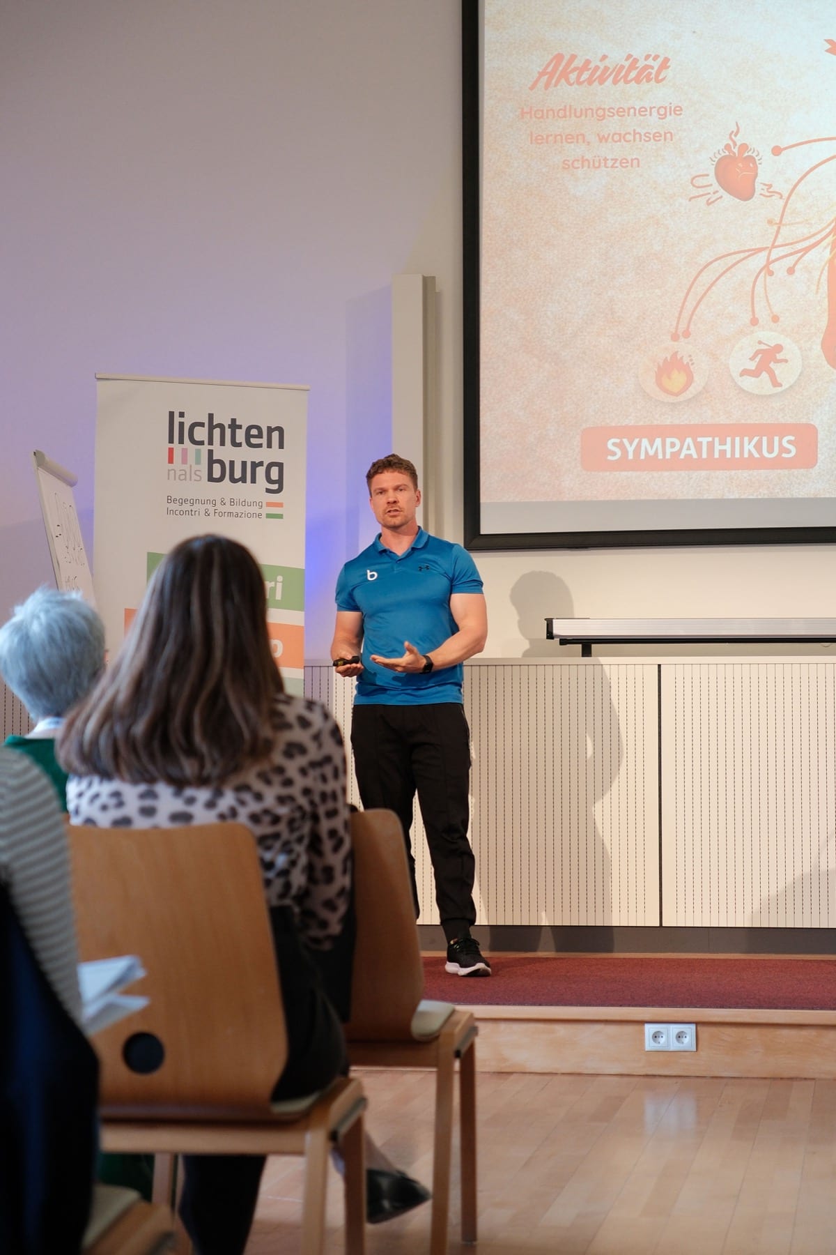Fabian Untersteiner hält einen Vortrag zu Gesundheit am Arbeitsplatz vor Publikum.